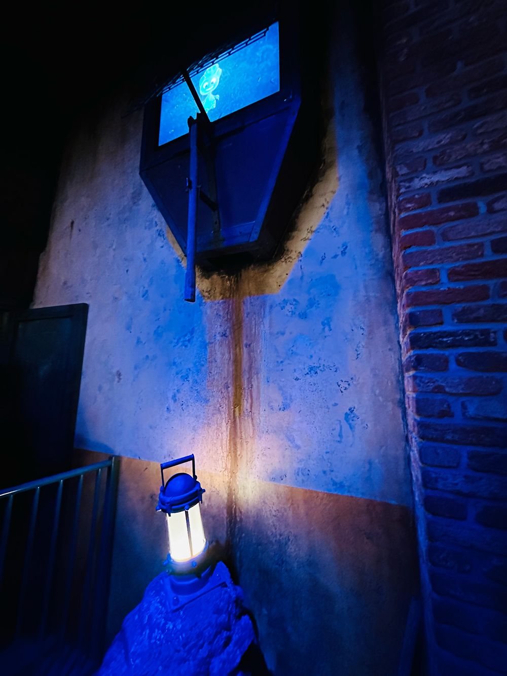 Illuminated lantern with Lüttje as a light projection in the dark queue area