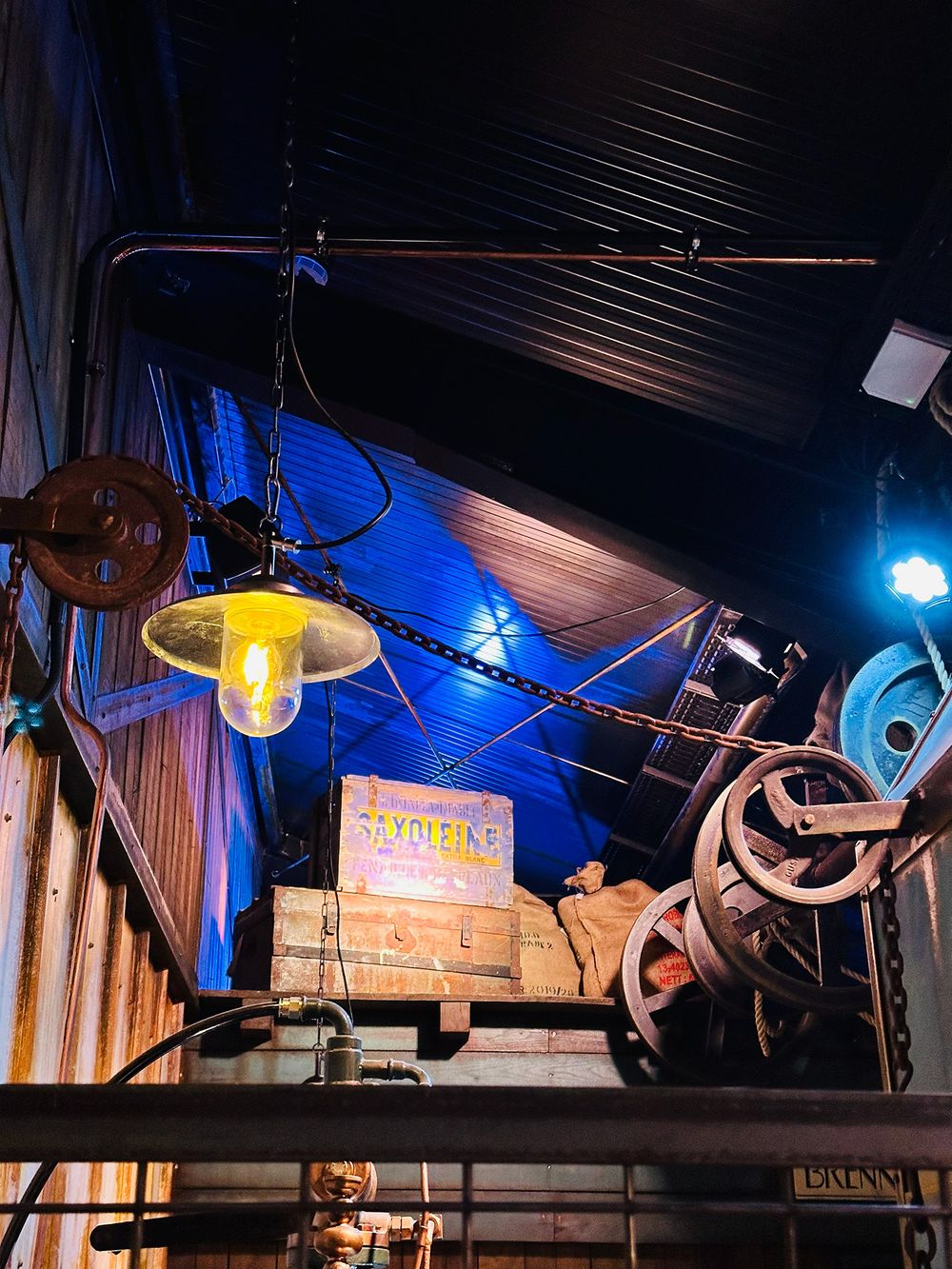 Lit props and historic machinery along the queue path